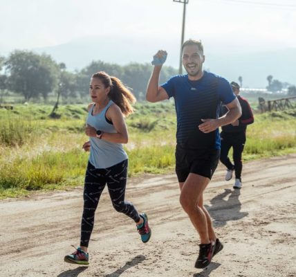 A group of runners enjoys a vibrant morning jog on a rural dirt road.