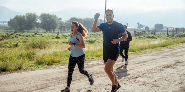 A group of runners enjoys a vibrant morning jog on a rural dirt road.